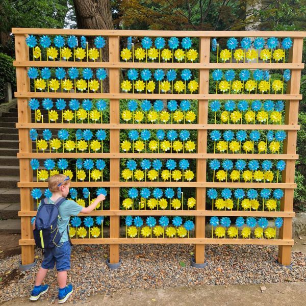 Child playing with yellow and blue windmills at Nezu temple - Tokyo - Japan - LiNGER Travel